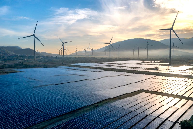 Wind turbines and solar farm at sunset